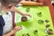 Boy squeezes the shapes from the molds on the rolled brown dough. Pressed shapes are next to prepared for bakin.