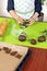Boy squeezes the shapes from the molds on the rolled brown dough. Pressed shapes are next to prepared for baking.