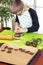 Boy squeezes the shapes from the molds on the rolled brown dough. Pressed shapes are next to prepared for baking.