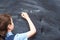 Boy standing back in front of school blackboard and writing. Schoolboy solves math example at the chalkkboard