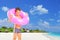 Boy standing on beach with swimming ring