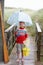 Boy standing on footbridge with umbrella