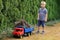 Boy standing by plastic truck filled by shrubs