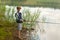 Boy standing on a shore and fishing