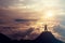 A boy standing on the top of the mountain above the clouds. Success Concept.