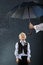 Boy standing under umbrella in rain