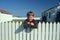 Boy standing at white picket fence