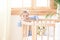 A boy stands alone beside a cot in the nursery. Lonely baby is in kindergarten near the crib. Loneliness. Eco-friendly children`s