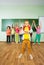 Boy stands in front of children with hands up