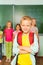 Boy stands in front of kids near blackboard