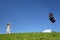 Boy stands on grass and starts kite