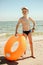 Boy stands with orange inflatable ring