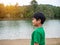 A boy stands by the reservoir in the evening. It shows looking at the goals in life