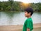 A boy stands by the reservoir in the evening. It shows looking at the goals in life