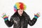 Boy stands in wig of clown and shows bright gloves