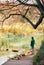 Boy stay near pond in autumn park, last sunny autumn days