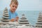 Boy and stone stacks on pebble beach