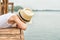 A boy in a straw hat lies on the wooden pier and looks at the water .Summer vacation on the lake