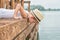 A boy in a straw hat lies on the wooden pier and looks at the water .Summer vacation on the lake