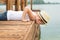 A boy in a straw hat sitting on the pier .Summer vacation on the lake