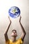 Boy stretching arms to grab planet Earth