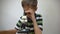 A boy in a striped T-shirt examines parts of the plant under a microscope.