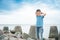 Boy in a striped T-shirt at the seaside breakwater block. boy standing on the beach. kid stands on a rock by the sea