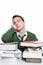 Boy student sleeping over stack books over desk