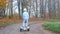 A boy in a suit of an astronaut on a gyroscooter makes a U-turn, climbs off him.
