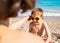 A boy in sunglasses plays on the beach