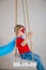 Boy a superhero in a blue Cape on a swing