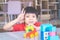 Boy surrounded by colorful toy blocks top view V shape hand for victory