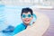 Boy in swim suit smiling in swimming pool