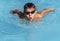 Boy swimmer swimming butterfly stroke in pool. Young athlete swim in swimming pool, training, competition, water sports