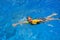 Boy swimming in blue water.