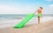 Boy with swimming mattress walks on sand sea beach