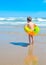 A boy with the swimming ring is walking on the beach .A child on a tropical beach. Sand and water fun, sun protection for s