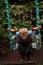 A boy swings on a swing in the backyard in autumn