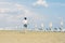 A boy in a T-shirt and shorts walks on the sandy Mackenzie beach in Larnaca. Cyprus