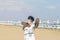 A boy in a T-shirt with sneakers on the sandy Mackenzie beach in Larnaca. Cyprus