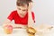 Boy at the table chooses between hamburger and apple on white background