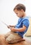 Boy, tablet and typing with games, relax or internet with network, connection or home. Child development, apartment or