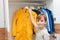 Boy taking jacket from hanger stand. Wardrobe with child`s clothing