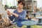 Boy taking little brush while sculpting clay figures