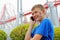 Boy talking on a mobile at an amusement park