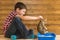 The boy teaches the little kitten walking in a tray, on wooden background wall
