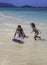 Boy teaching sister to skim board