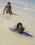 Boy teaching sister to skim board