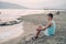 Boy teen sits on the beach and looks at the sea in Alanya city