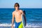 Boy teen surfer happy holing surfboard on the beach